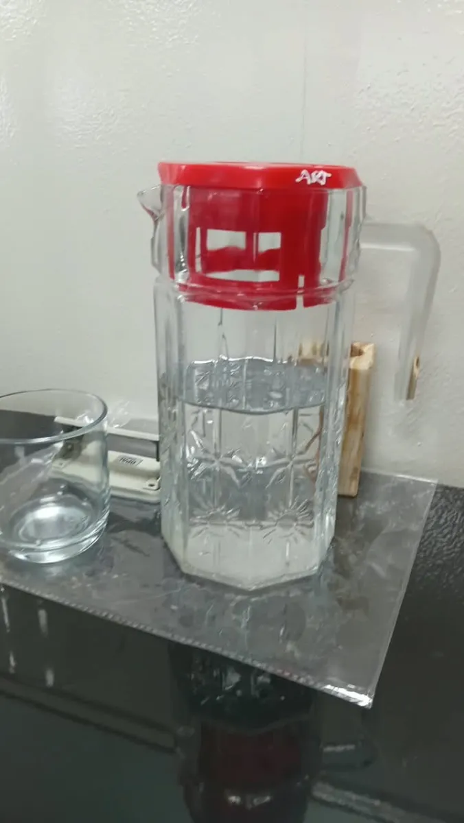 Glass water jug with red lid